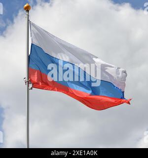 La bandiera della Federazione Russa su un palo, svolazzando nel vento, contro il cielo Foto Stock