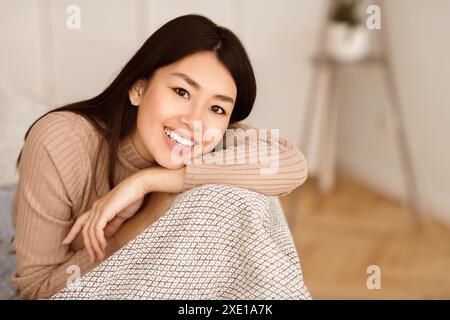 Donna che sorride su una coperta Foto Stock