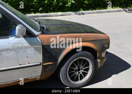 Frammento di una BMW arrugginita all'aperto Foto Stock