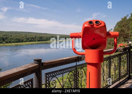 Binocolo pubblico stazionario sulle rive del fiume in estate Foto Stock