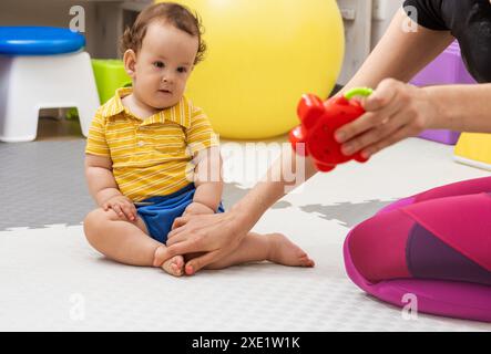 Fisioterapia infantile. Il bambino riceve una terapia fisica da uno specialista Foto Stock