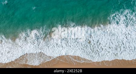 Le onde si infrangono sulle coste sabbiose da una prospettiva superiore. Foto Stock