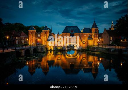 Fortezza medievale, cancello delle mura della città di Koppelpoort e fiume EEM nella città di Amersfoort di notte, Neth Foto Stock