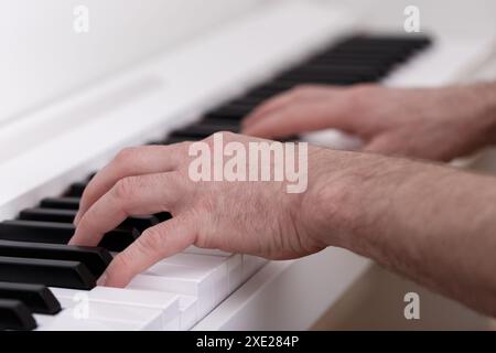 Giovane che suona al pianoforte bianco moderno Foto Stock