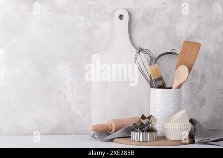 Piano cucina con moderna ceramica bianca e stoviglie in legno contro pareti in pietra grigia Foto Stock