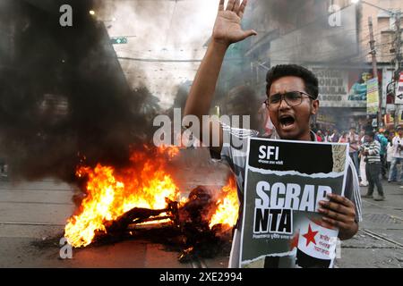 Kolkata, India. 25 giugno 2024. Un attivista che protesta mentre le gomme e un'effigie bruciano durante una protesta contro la recente truffa nell'esame NEET e UGC-NET. Studenti di numerosi partiti politici hanno protestato contro presunte irregolarità governative. Il 25 giugno 2024 a Kolkata, India. (Foto di Dipa Chakraborty/ credito: Eyepix Group/Alamy Live News Foto Stock