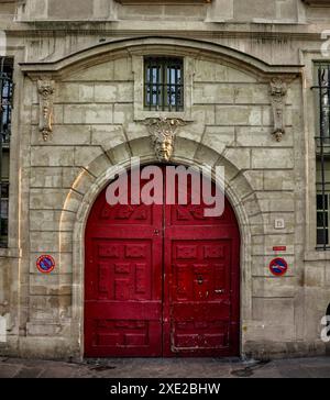 Hôtel le Charron con porta in legno rosso vintage a Parigi, tipica porta in legno rosso vintage con un rilievo di un animale fantastico Foto Stock