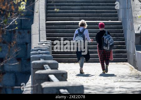 Mosca, Russia - 28 aprile 2019: Due amiche si impegnano in una vivace discussione su una scalinata illuminata dal sole. Foto Stock