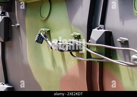 Lucchetto che fissa la porta di un veicolo militare. L'automobile è dipinta con uno schema mimetico. Concetto di pace Foto Stock