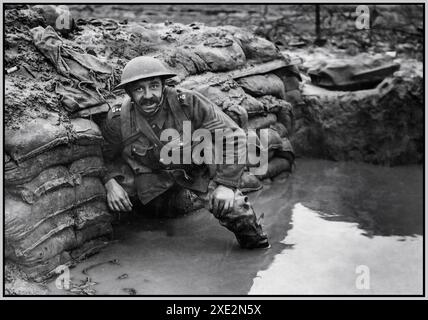 Sergente dell'esercito britannico della prima guerra mondiale in piedi stoicamente in una trincea allagata nel nord della Francia. La battaglia di 'PASSCHENDAELE' 1914-1918 prima guerra mondiale. La battaglia di Passchendaele, nota anche come terza battaglia di Ypres, fu una delle più importanti battaglie della prima guerra mondiale. Ebbe luogo sul fronte occidentale, tra il 31 luglio e il 10 novembre 1917, vicino alla città di Passchendaele (oggi Passendale) nelle Fiandre occidentali, in Belgio. La battaglia faceva parte di una serie di offensive guidate dai britannici nel saliente di Ypres, con l'obiettivo di sfondare le difese tedesche e proteggere la costa belga. Foto Stock