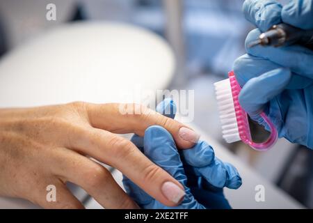 Mani e strumenti femminili per la manicure, processo di esecuzione della manicure Foto Stock