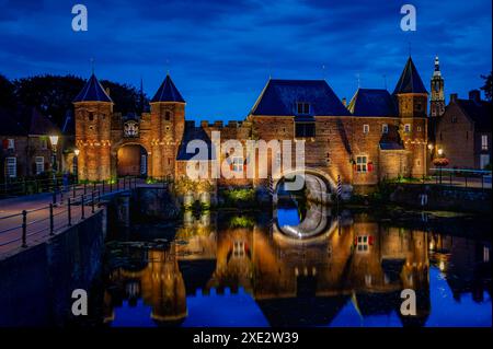 Fortezza medievale, cancello delle mura della città di Koppelpoort e fiume EEM nella città di Amersfoort di notte, Nethe Foto Stock