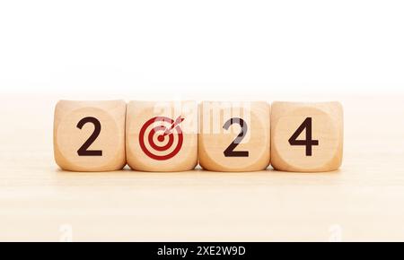 2024 concetto di obiettivi aziendali. Blocchi di legno con numero 2024 e icona obiettivo. Copia spazio Foto Stock