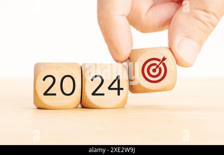 2024 concetto di obiettivi aziendali. Blocchi di legno con numero 2024 e icona obiettivo. Copia spazio Foto Stock