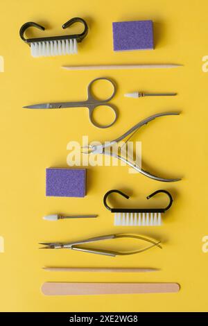 Strumenti professionali per manicure su sfondo giallo. Set manicure. Foto Stock