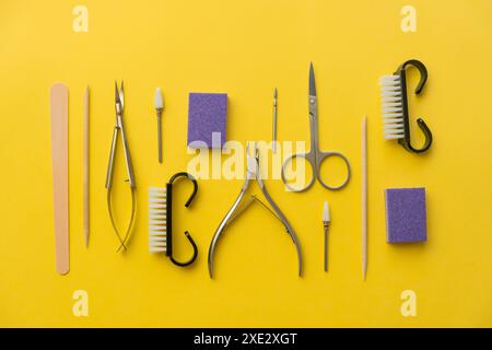 Strumenti professionali per manicure su sfondo giallo. Set manicure. Foto Stock