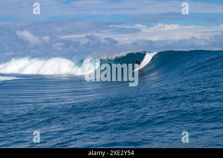 Teahupoo, Tahiti, Polinesia francese - 7 giugno 2024 - sa surfista che affronta un'onda mostruosa. Teahupoo è la sede dell'evento olimpico di surf 2024. Foto Stock