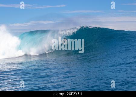 Teahupoo, Tahiti, Polinesia francese - 7 giugno 2024 - un surfista che affronta un'onda mostruosa. Teahupoo è la sede dell'evento olimpico di surf 2024. Foto Stock