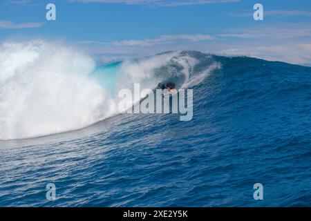 Teahupoo, Tahiti, Polinesia francese - 7 giugno 2024 - un surfista che affronta un'onda mostruosa. Teahupoo è la sede dell'evento olimpico di surf 2024. Foto Stock