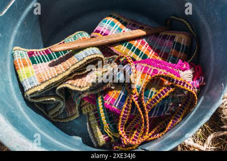 cinturini e in fibra di alpaca stesi a terra accompagnati da strumenti a telaio in una giornata di sole Foto Stock