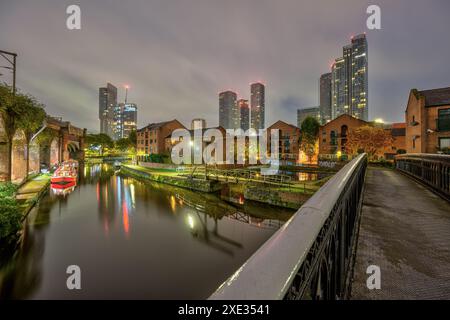 Castlefield a Manchester, Regno Unito, di notte con lo skyline moderno sul retro Foto Stock