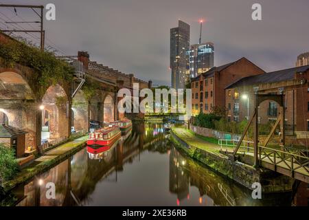 Castlefield a Manchester, Regno Unito, di notte, con un moderno grattacielo sul retro Foto Stock