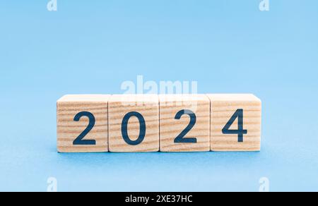 2024 su blocchi di legno isolati su sfondo blu. Copia spazio Foto Stock