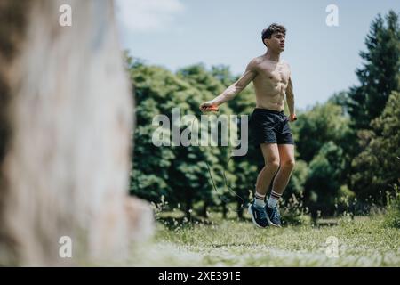 Un giovane salta all'aperto in un parco durante una giornata di sole Foto Stock