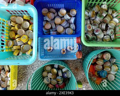 Phang Nga, Thailandia - 21 febbraio 2024: Tappi a vite in metallo сollecting per il riciclaggio. Tappi e coperchi di bottiglie per bevande energetiche in contai di plastica separati Foto Stock