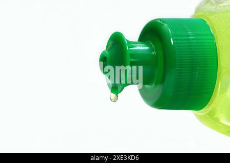 Liquido per lavastoviglie. Macro shot di bottiglia di lavaggio di piatti da cucina verde distesa e un liquido per lavastoviglie Foto Stock