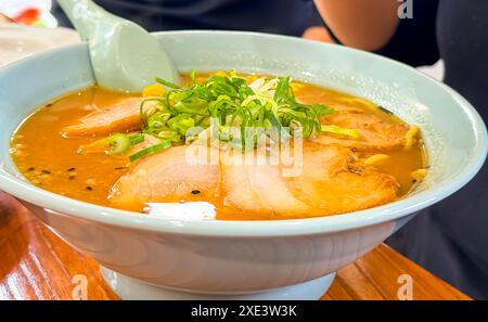 Un ramen Tonkotsu, un delizioso brodo di maiale cremoso, tradizionalmente servito con lunghi spaghetti sottili e condito con una varietà di spaghetti Foto Stock