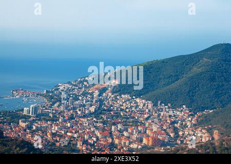 Skyline della città costiera con una maestosa montagna che torreggia in lontananza. Vista aerea della città di Budva in Montenegro Foto Stock