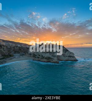 Vista della spiaggia di Rotonda e della colorata città vecchia di Tropea in Calabria al tramonto Foto Stock