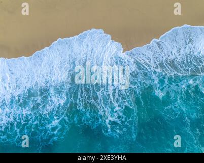 Vista dall'alto della spiaggia di sabbia dorata di Rotonda a Tropea con acqua turchese e onde che si infrangono sulla riva Foto Stock