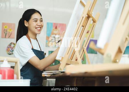 Ispirazione per la creazione: Artista femminile che abbozza e dipinge in officina Foto Stock