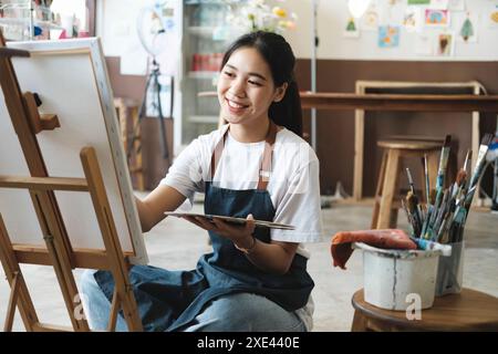 Creare ispirazione. Artista femminile Sketching and Painting in Workshop Foto Stock