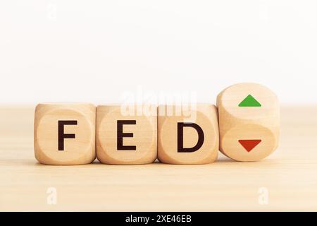 FED o Federal Reserve controllano il concetto di aumento o diminuzione dei tassi di interesse. Blocchi di legno con testo e frecce. Copia spazio Foto Stock