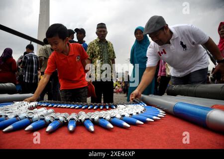 Giacarta, Indonesia - 13 dicembre 2014 : i residenti di Giacarta stanno guardando i tipi di proiettili di aerei da combattimento alla mostra TNI Combat Equipment at Foto Stock