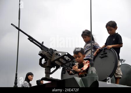 Giacarta, Indonesia - 13 dicembre 2014: I bambini provano armi da combattimento su carri armati alla mostra di equipaggiamento da combattimento TNI a Monas, Giacarta - Indonesia Foto Stock
