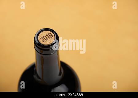 Bottiglia di vino bianco con sughero su sfondo beige Foto Stock