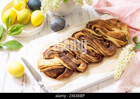 Cottura di Pasqua. Babka al cioccolato pasquale o pane brioche fatto in casa. Impasto dolce a base di lievito con ripieno di cioccolato e accompagnato e nu Foto Stock