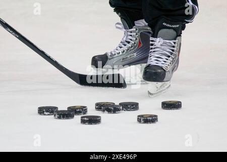 Calgary, Alberta, Canada. 10 giugno 2023. Primo piano di un giocatore di hockey che scivola sul ghiaccio, maneggia un bastone e ne manovra alcuni Foto Stock