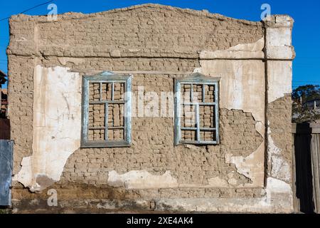 Muro in mattoni d'aria in mattoni d'epoca con due telai delle finestre in legno e sbucciati in gesso - struttura piatta Foto Stock