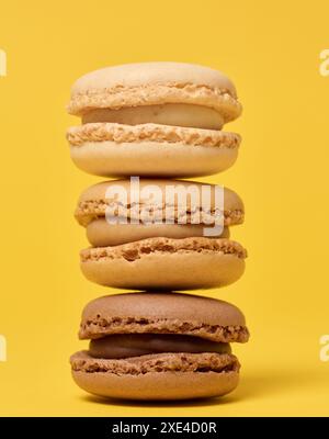 Pila di macaron di cioccolato su sfondo giallo Foto Stock