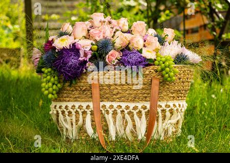 Bellissimo bouquet di fiori colorati con rose e altri fiori in un cestino Foto Stock