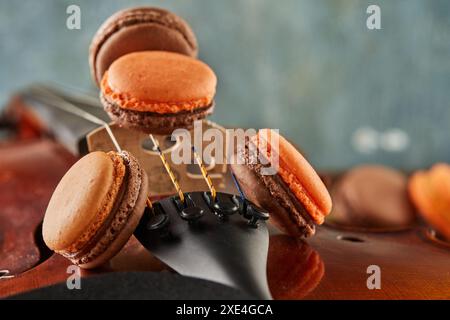 Macaroni colorati disposti su violino, sfondo in legno. Foto Stock