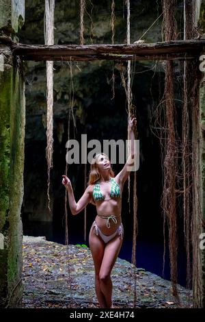 Serenity Unveiled: Una splendida meraviglia della modella tra gli incantevoli cenote blu e verdi di Cuzama nello Yucatan, Messico Foto Stock