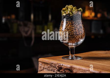 Luppolo e frumento in un bicchiere per birra Foto Stock