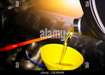 Il servizio di manutenzione della vettura , il versamento dell'olio motore in un imbuto per la manutenzione del motore della vettura include un'astina di livello dell'olio per la misurazione del livello dell'olio , Car Repair ga Foto Stock