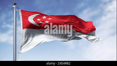 Bandiera nazionale di Singapore che sventola nel vento in una giornata limpida Foto Stock